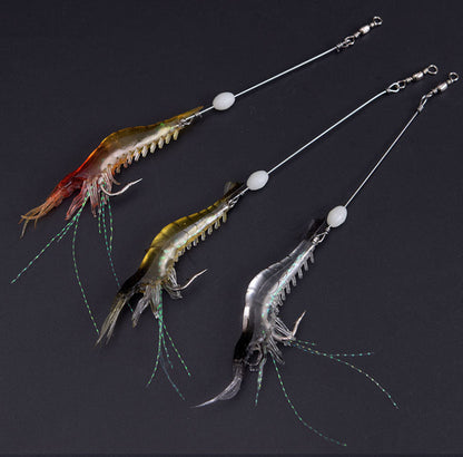Three fishing lures shaped like shrimp or prawns, each attached to a long silver wire with a white bead and split ring, displayed on a dark background.