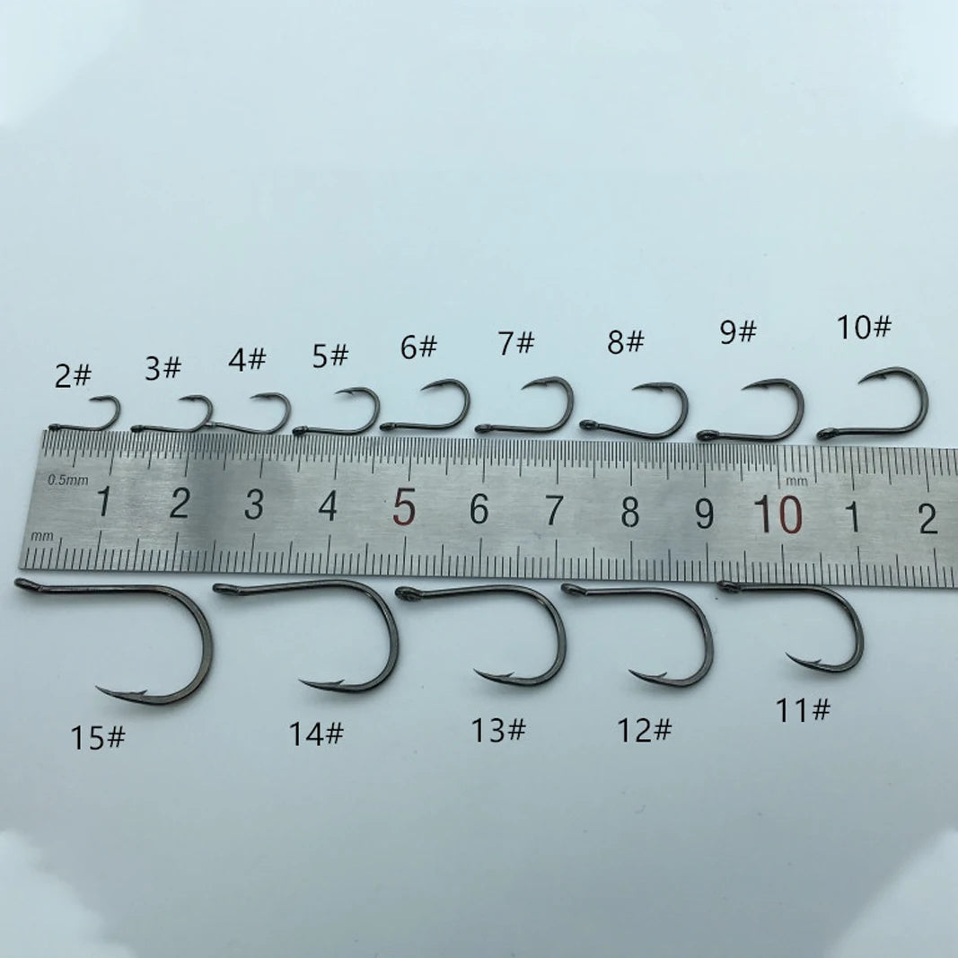 Set of fishing hooks with size markings on a ruler against a light gray background
