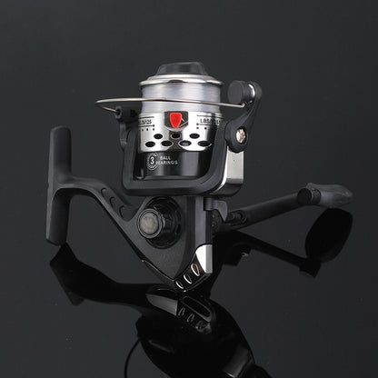 Fishing reel with metallic finish on a reflective black surface