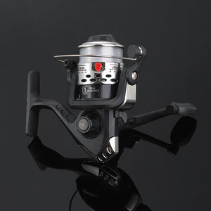 Fishing reel with metallic finish on a reflective black surface