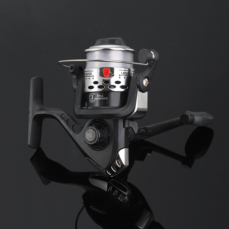Fishing reel with metallic finish on a reflective black surface