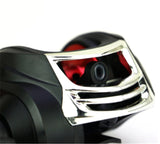 Close-up of a motorcycle headlight with chrome finish and red interior on a white background