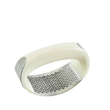 White garlic press on a white background