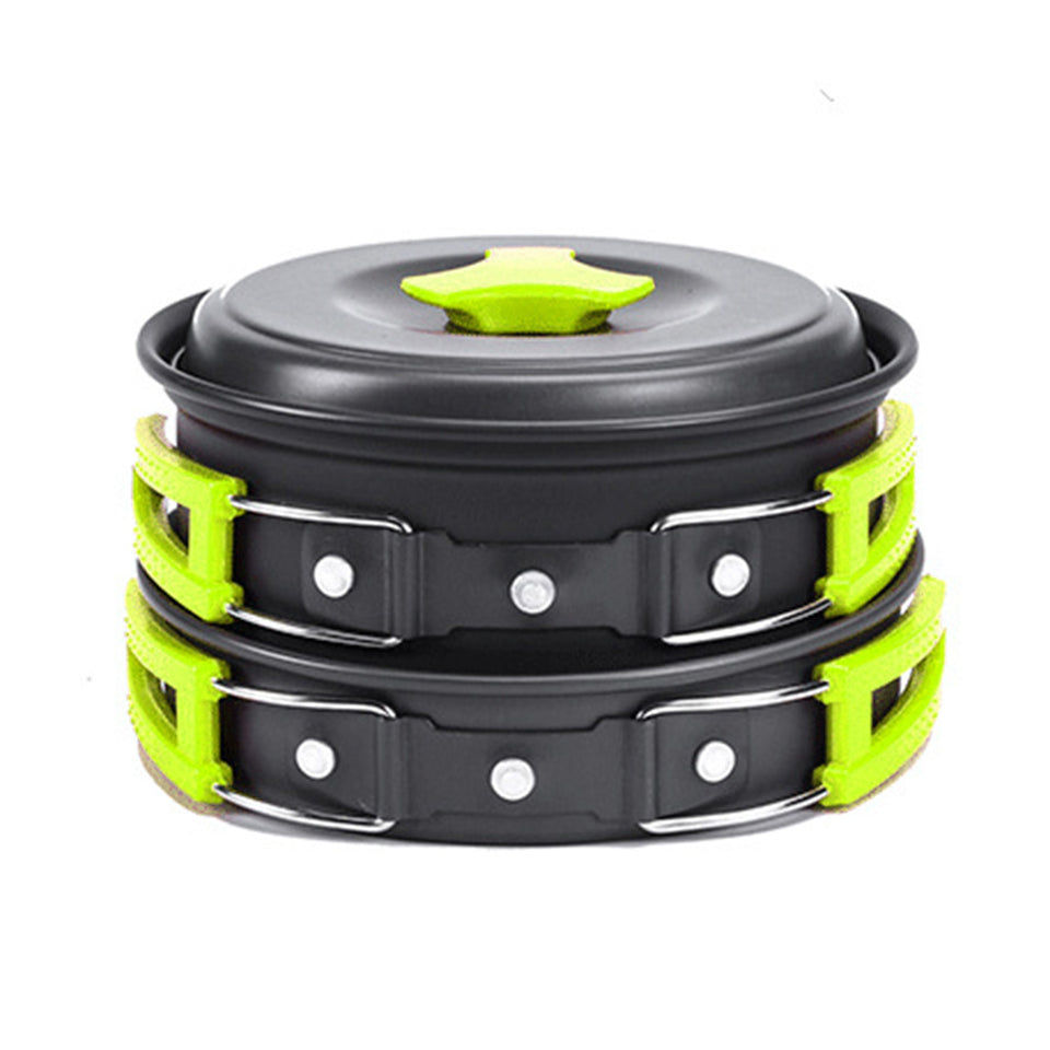 Stack of black and green cookware with a lid on a white background
