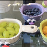 Cartoon-style drain baskets with fruits on a reflective surface