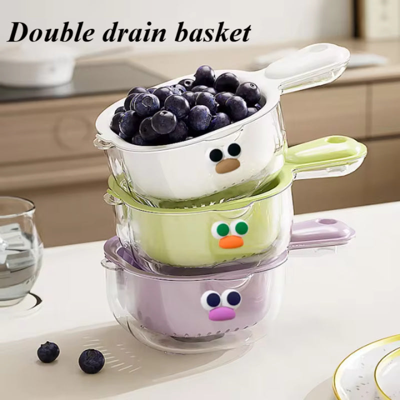 Double drain basket with cartoon face filled with blueberries on a kitchen counter.